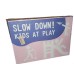 Slow down ! Kids at play . Pink sign